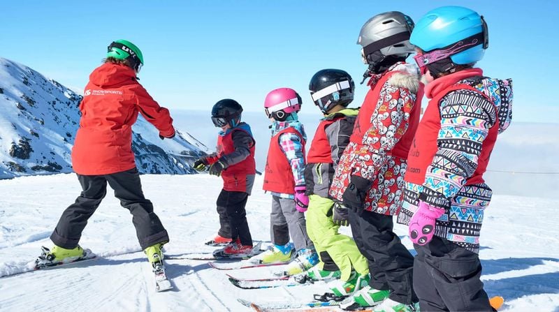 Ski instructor teaching a group of children to ski at Mt Hutt