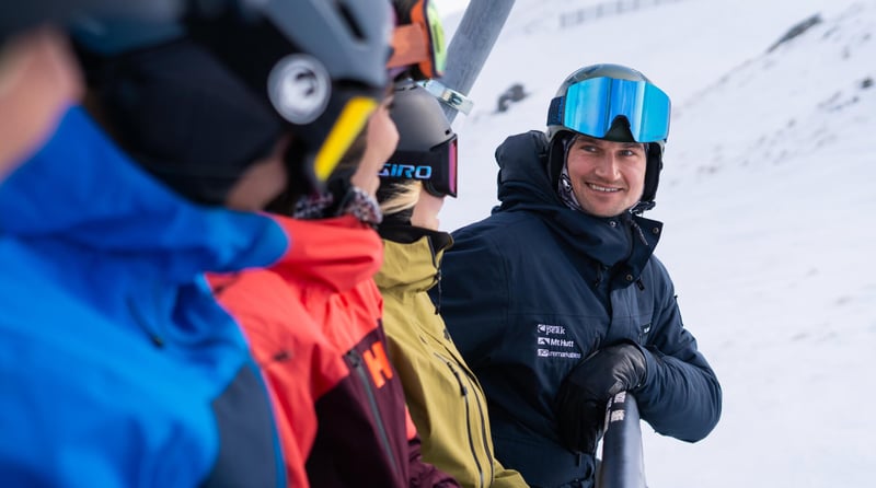 Ski instructor chatting with skiers on a chairlift at Mt Hutt