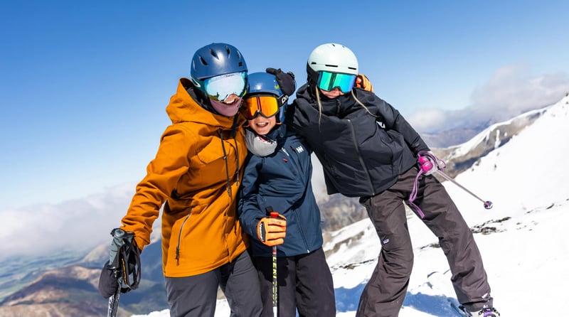 Family of skiers smiling together at Mt Hutt with alpine views