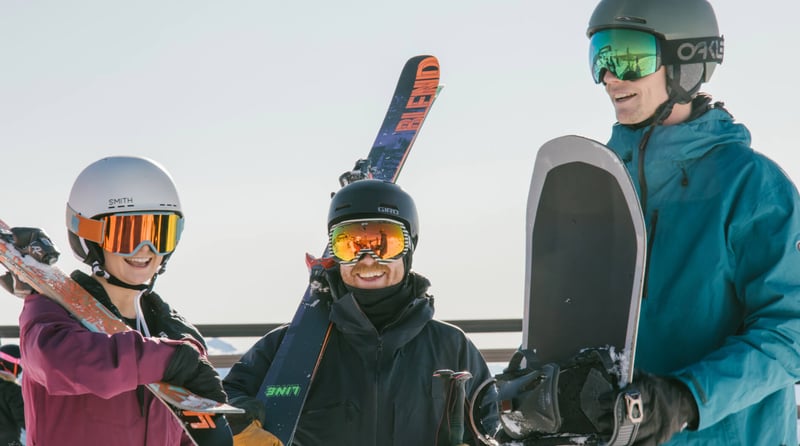 Group of skiers and a snowboarder smiling with gear at Mt Hutt ski field